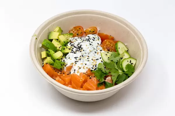 Gesundes Gericht mit Lachs, Avocado, Tomate, Gurke und Petersilie in Schale