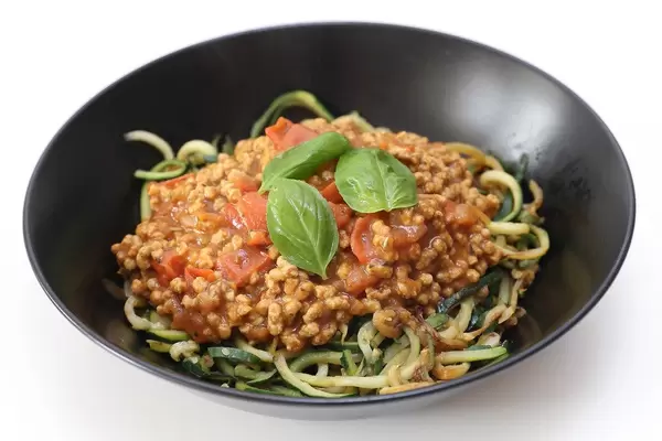 Gesundes Mittagessen für vegane Ernährung, mit Sonnenblumen-Bolognese als Fleischersatz und grünen Zucchini-Spaghetti