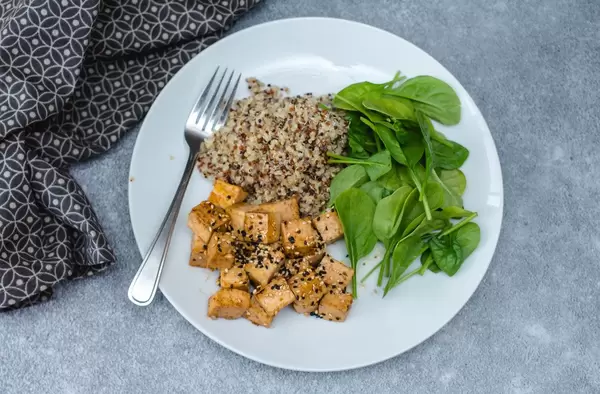 Gesundes Mittagessen: Tofu, Spinatbläter und Quinoa als Beilage