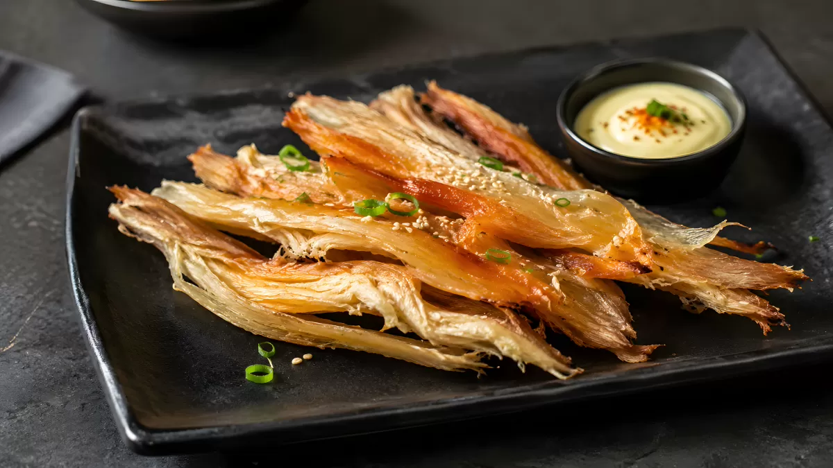 Getrockneter Tintenfisch mit Sesam und Dip auf Teller
