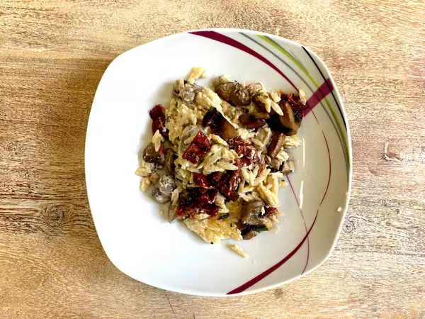 Getrüffeltes Pastasotto mit Parmesan, getrockneten Tomaten, Pilzen und Kräutern