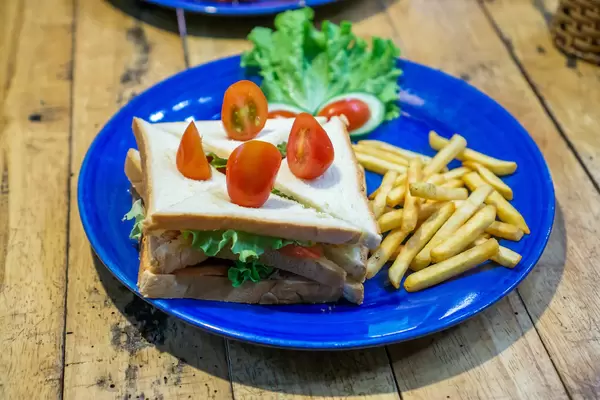 Gevierteltes Thunfisch Sandwich mit Pommes und Kirschtomaten Nahaufnahme