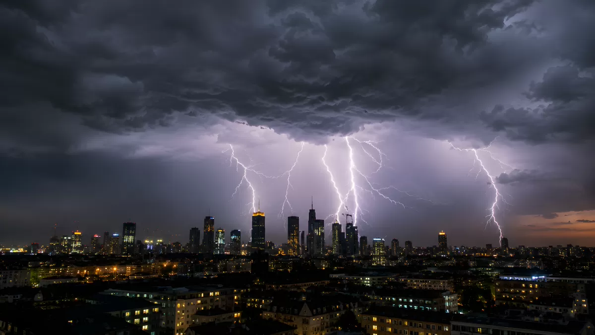 Gewitter über beleuchteter Großstadt bei Nacht