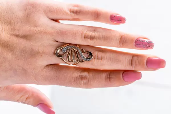 Gewschwungener Ring als Frauenschmuck an der Hand eines Mädchens