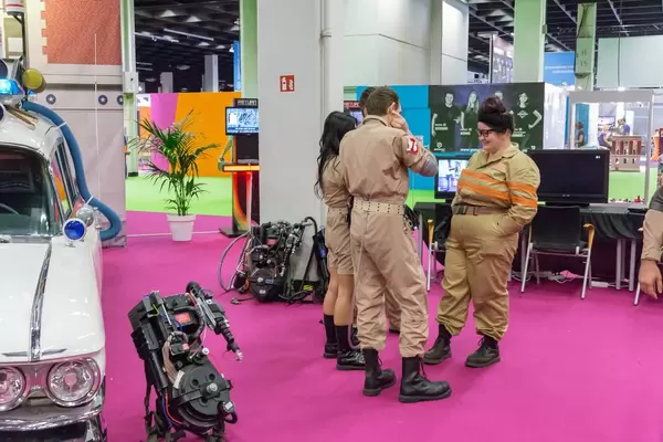 Ghostbusters Darsteller neben Ecto-1 und Proton Pack