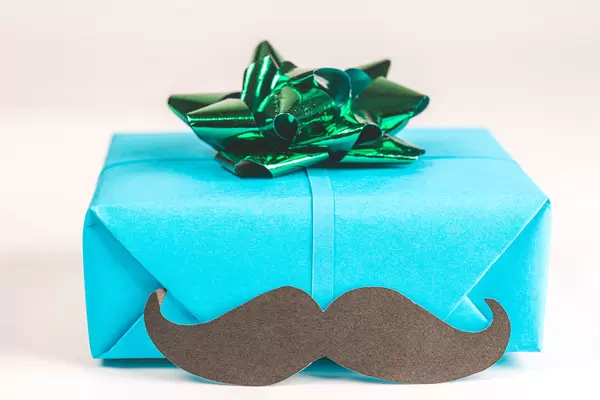 Gift blue box with green bow and black mustache