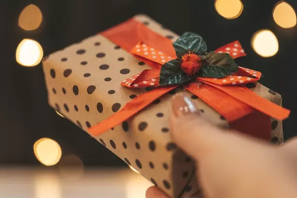 Gift box in hand on bokeh background of glowing garland (Flip 2019)
