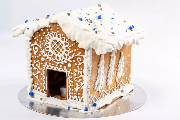 Gingerbread house with glaze ornament on white background