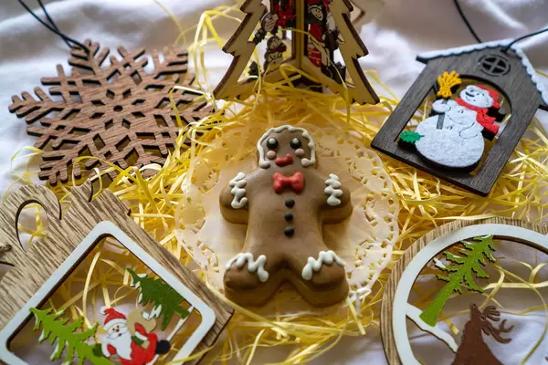 Gingerbread Man Christmas Cookie with Different Wooden Christmas Decorations such as Christmas Tree, Snowflake, Santa Claus and Snowman