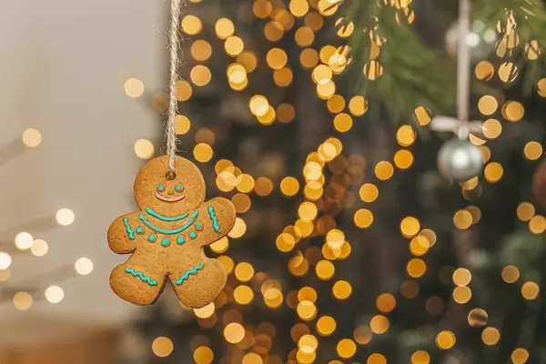 Gingerbread man hanging on golden bokeh background