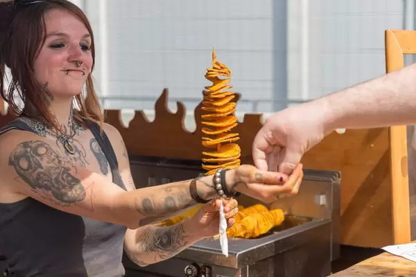 Girl handing out tornado potato to a customer