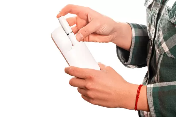 Girl holding tobacco heating system device with tobacco stick