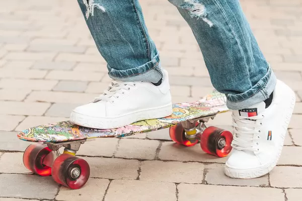 Girl in white sneakers on a skateboard