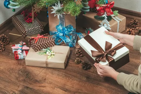 Girl puts gifts under the Christmas tree in the living room (Flip 2019)