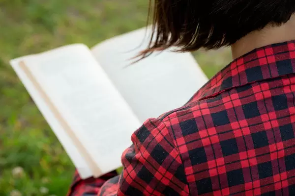 Girl reading a book, view from the back