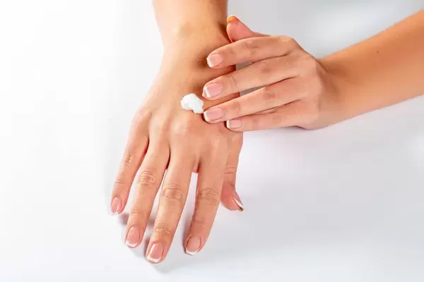 Girl spreads her hands with cream