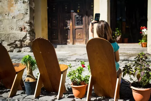 Girl taking a selfie on wooden chairs