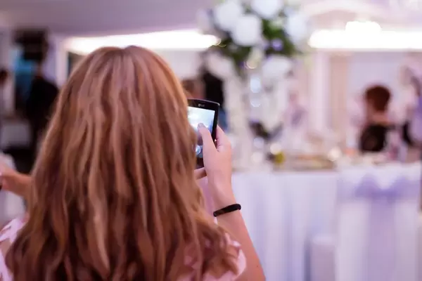 Girl taking photo with a smartphone at a wedding