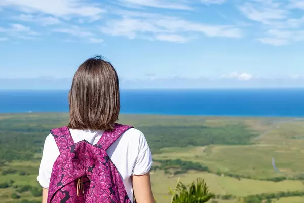 Girl with backpak looks to the ocean from Redonda mountine at Dominican Republic