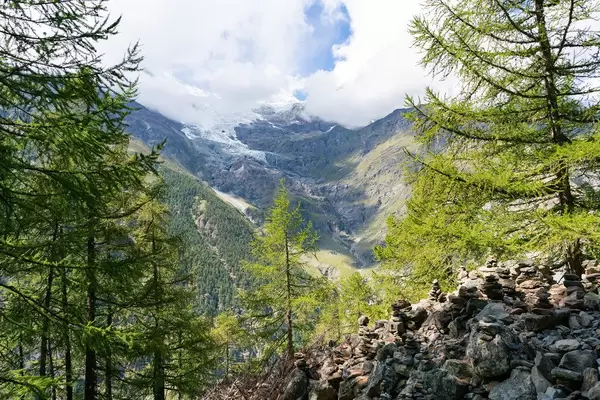 Glacier of mountain Weisshorn with small rocks in the foreground along the hiking pass