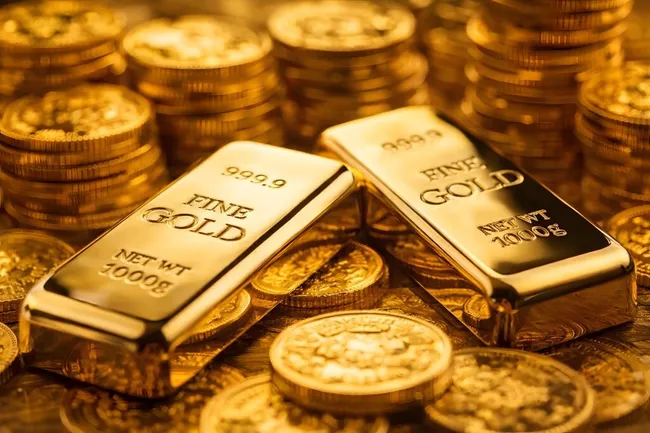 Glänzende Goldbarren und Münzen als Symbol für Vermögen