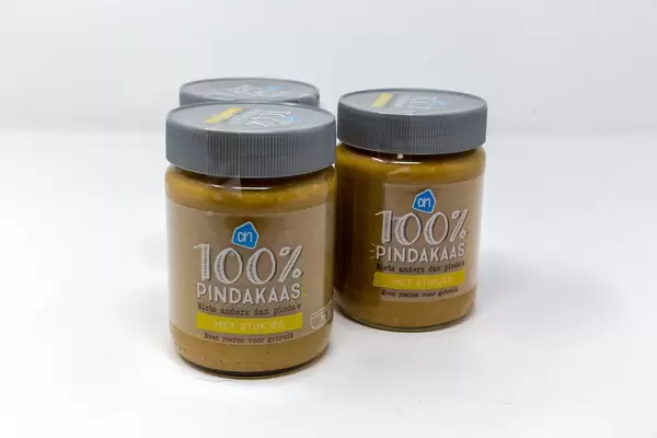 Gläser mit reinem Pindakaas, Erdnussbutter auf Holländisch, mit Stücken