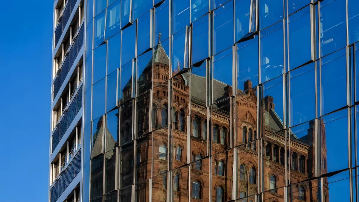 Glasfassade reflektiert historisches Gebäude