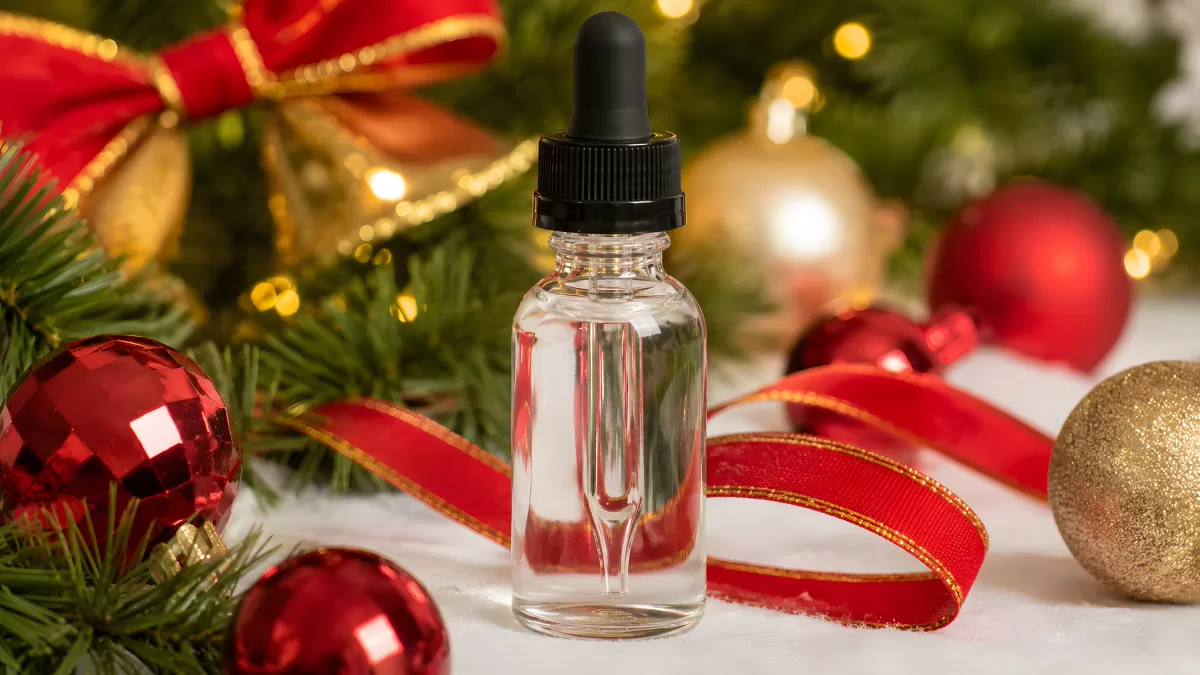 Glasfläschchen mit Pipette zwischen Weihnachtsdeko