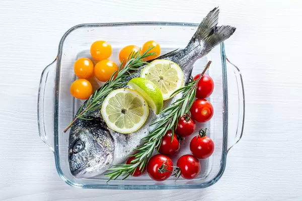 Glass baking sheet with raw Dorado fish and vegetables (Flip 2019)