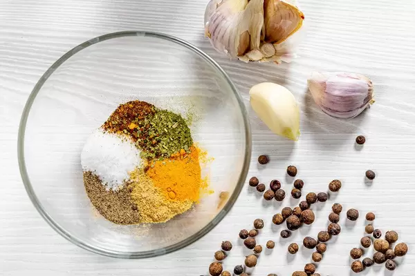 Glass bowl with spices on white wooden background. Top view (Flip 2019)