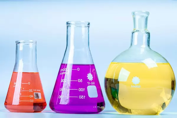 Glass flasks of different shapes with colored solutions. Concept of chemical experiments (Flip 2020)
