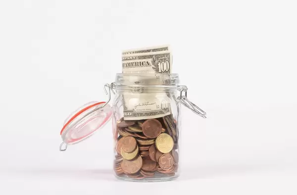 Glass jar for money on white background