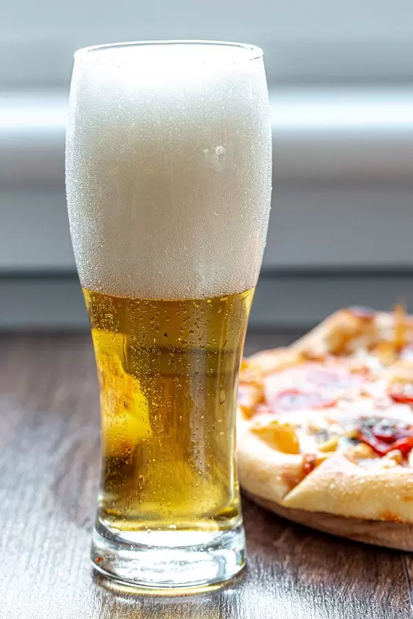 Glass of beer with foam and pizza on the table (Flip 2019) (Flip 2019)