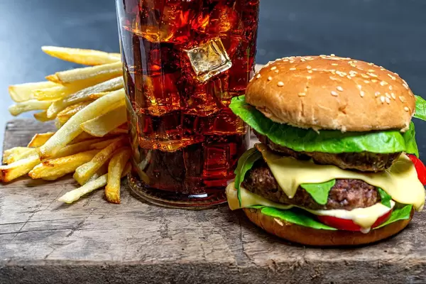Glass of Cola with ice, French fries and Burger close-up