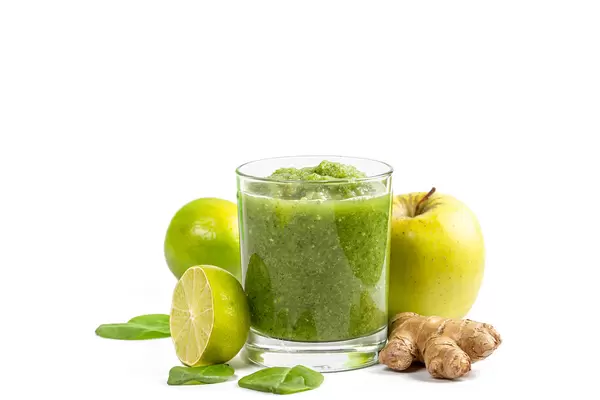 Glass of green smoothie with apple, lime, ginger root and spinach leaves