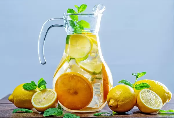 Glass of lemonade with ice cubes and mint leaves on wooden background (Flip 2019)