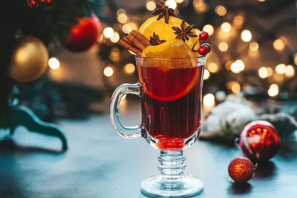 Glass of mulled wine on a beautiful Christmas background with Christmas tree and bokeh (Flip 2019)