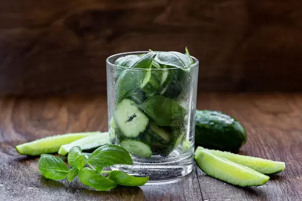 Glass with cucumber slices and Basil leaves - ingredients for green smoothie