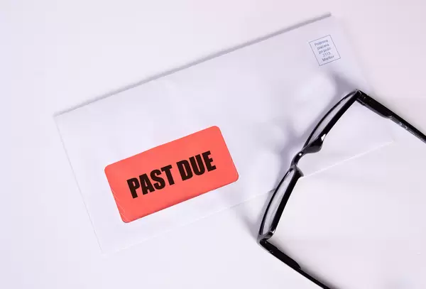 Glasses and envelope with Past Due text