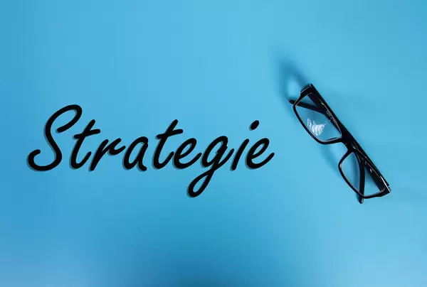Glasses with Strategie text on blue background