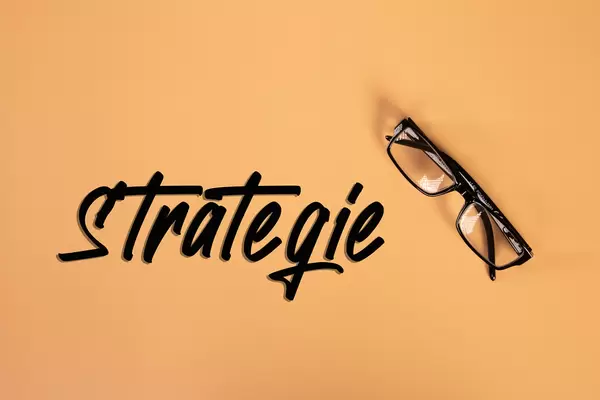 Glasses with Strategie text on orange background