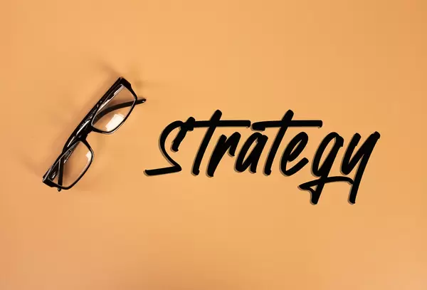 Glasses with Strategy text on orange background