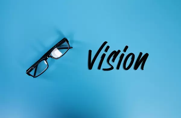Glasses with Vision text on blue background