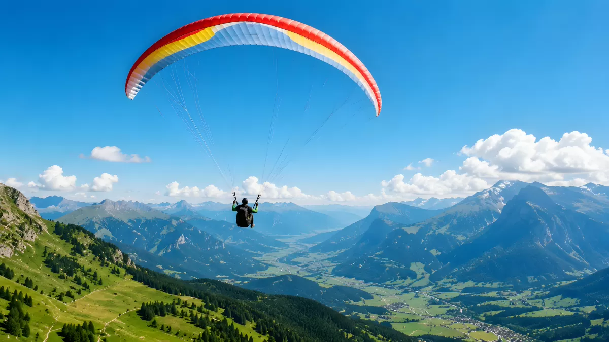 Gleitschirmflieger über alpinem Tal mit Bergpanorama
