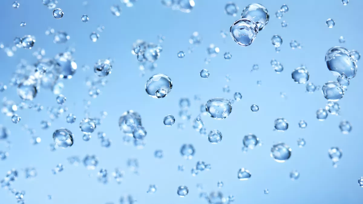 Glitzernde Wasserblasen schweben auf blauem Hintergrund