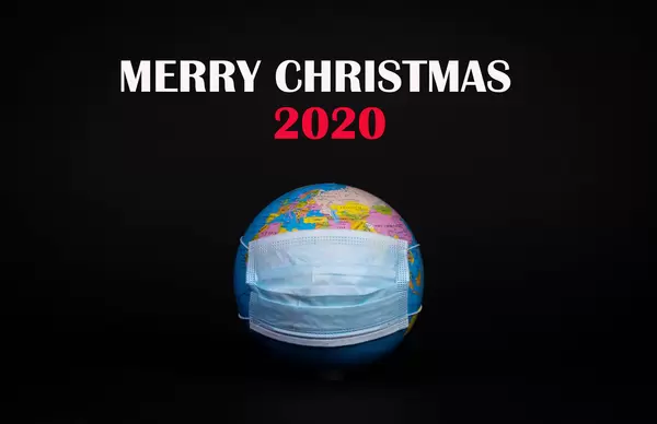 Globe with face mask and Merry Christmas 2020 text on black background