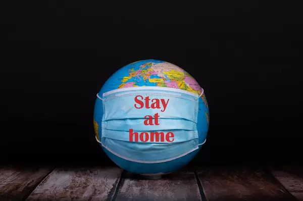 Globe with face mask and Stay at home text