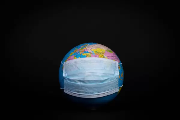 Globe with face mask on black background