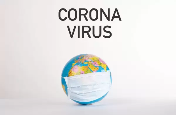Globe with medical mask and Corona Virus text on white background
