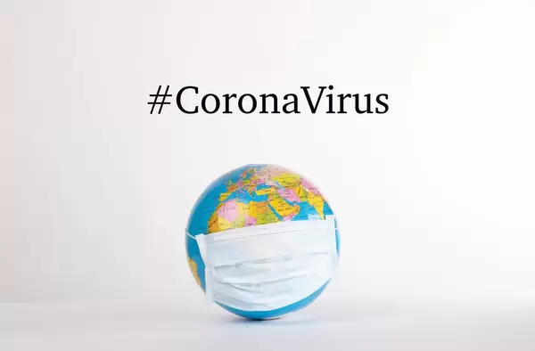 Globe with medical mask and #CoronaVirus text on white background
